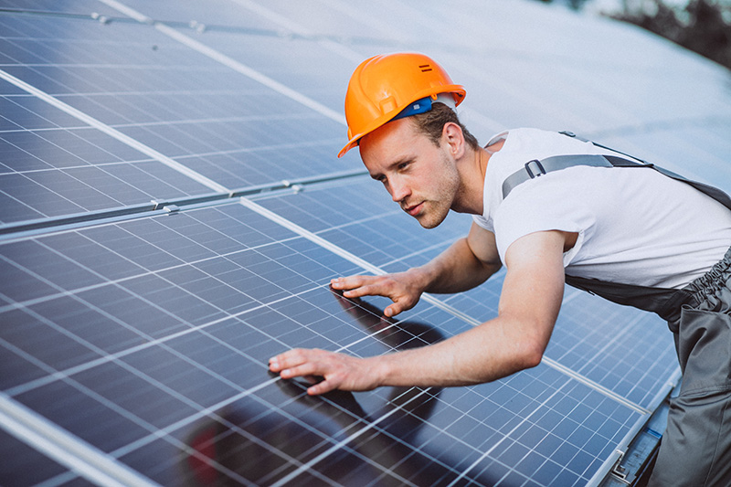 Man worker in the firld by the solar panels